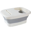 A white and gray collapsible foot spa bucket with a removable insert for massage nodules.