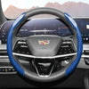 A close-up view of a black steering wheel with blue carbon fiber accents and an Aston Martin logo.