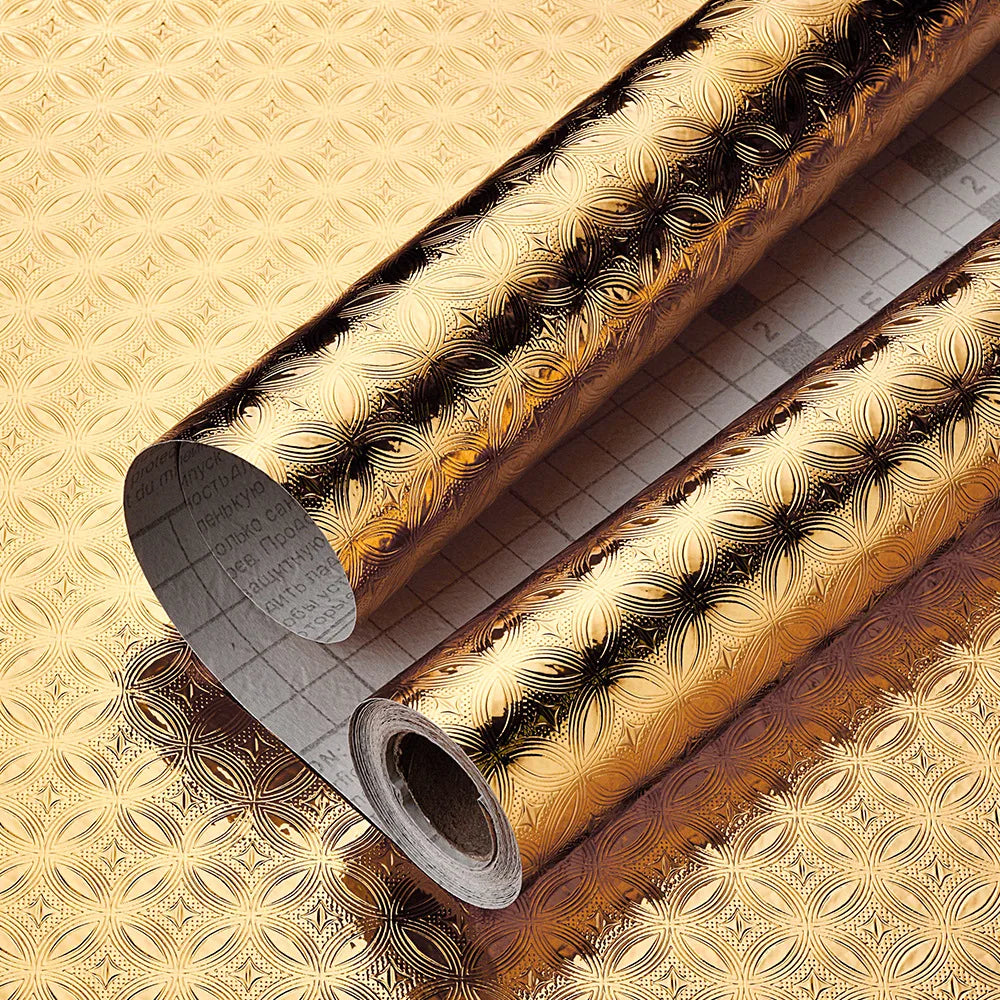 Roll of gold patterned aluminum foil kitchen wall stickers shown diagonally on a textured surface