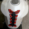 A close-up view of a white motorcycle tank pad protector with a black and red fish bone design.
