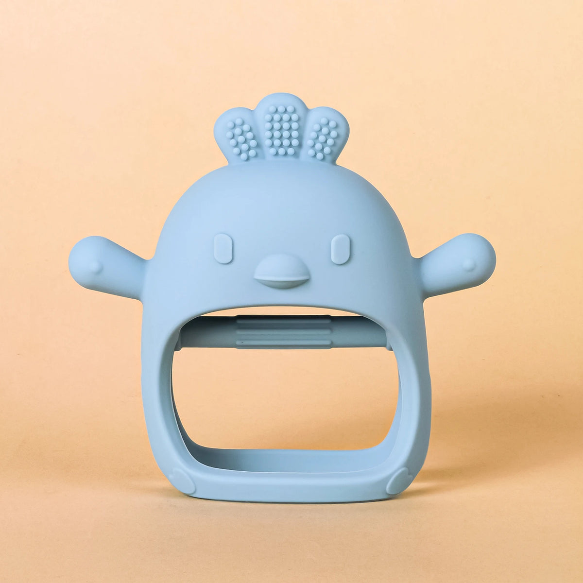 A light blue silicone teether shaped like a chick with a textured top and a wide opening for baby gums.