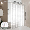 White striped shower curtain hanging on a rod in a modern bathroom setting