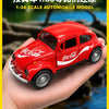 A red Coca-Cola branded 1:36 scale model of a vintage Volkswagen Beetle car held in a person's hand.