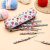 A set of ergonomic crochet hooks with a sunflower design, packaged in a floral-patterned case.