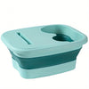 A teal collapsible foot spa bucket with two massage nodules.