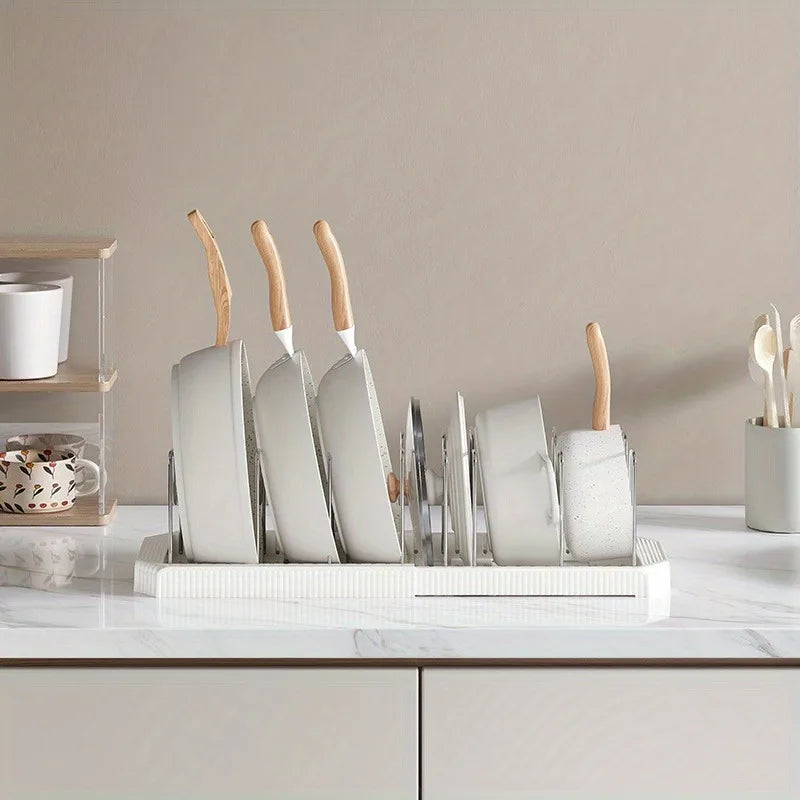 A white organizer rack holds several white spatulas with wooden handles on a marble countertop.
