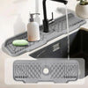 A silicone kitchen sink splash guard and faucet drip tray with a soap dispenser and a green silicone mat.