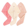 Three folded pink and beige microfiber hair drying towels with secure button closures