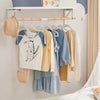 A display of kids' velvet hangers with 360° swivel hooks hanging various colored children's clothing on a white shelf.