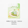 A green embroidered iron-on patch featuring a slice of cake with white frosting and decorative elements.