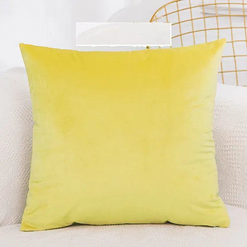 A bright yellow velvet decorative cushion cover resting on a white textured surface.