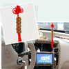 Chinese Feng Shui wealth coins with red handmade knot displayed in a car interior.