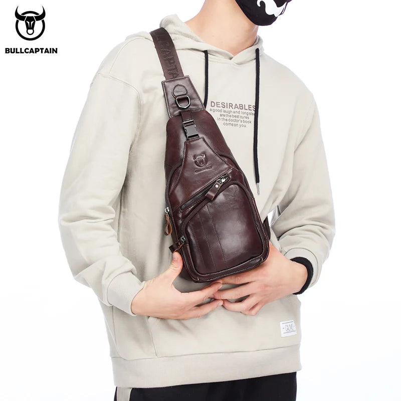 A man wearing a beige hoodie holds a brown genuine leather chest bag with a laptop compartment.
