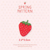A red strawberry 3D embroidery patch with green leaves on a light pink background.