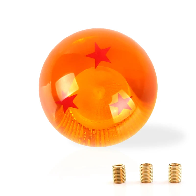 A round, orange gear shift knob with a star design and brass threads is shown against a white background.