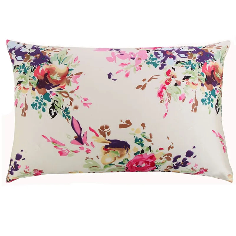 Quadernes Seidenkissenbezug mit Aquarell-Blumenmuster in Rosa, Lila und Grün auf cremefarbgem Hintergrund.