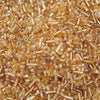 Close-up of mixed glass seed beads in various shades of amber and gold.