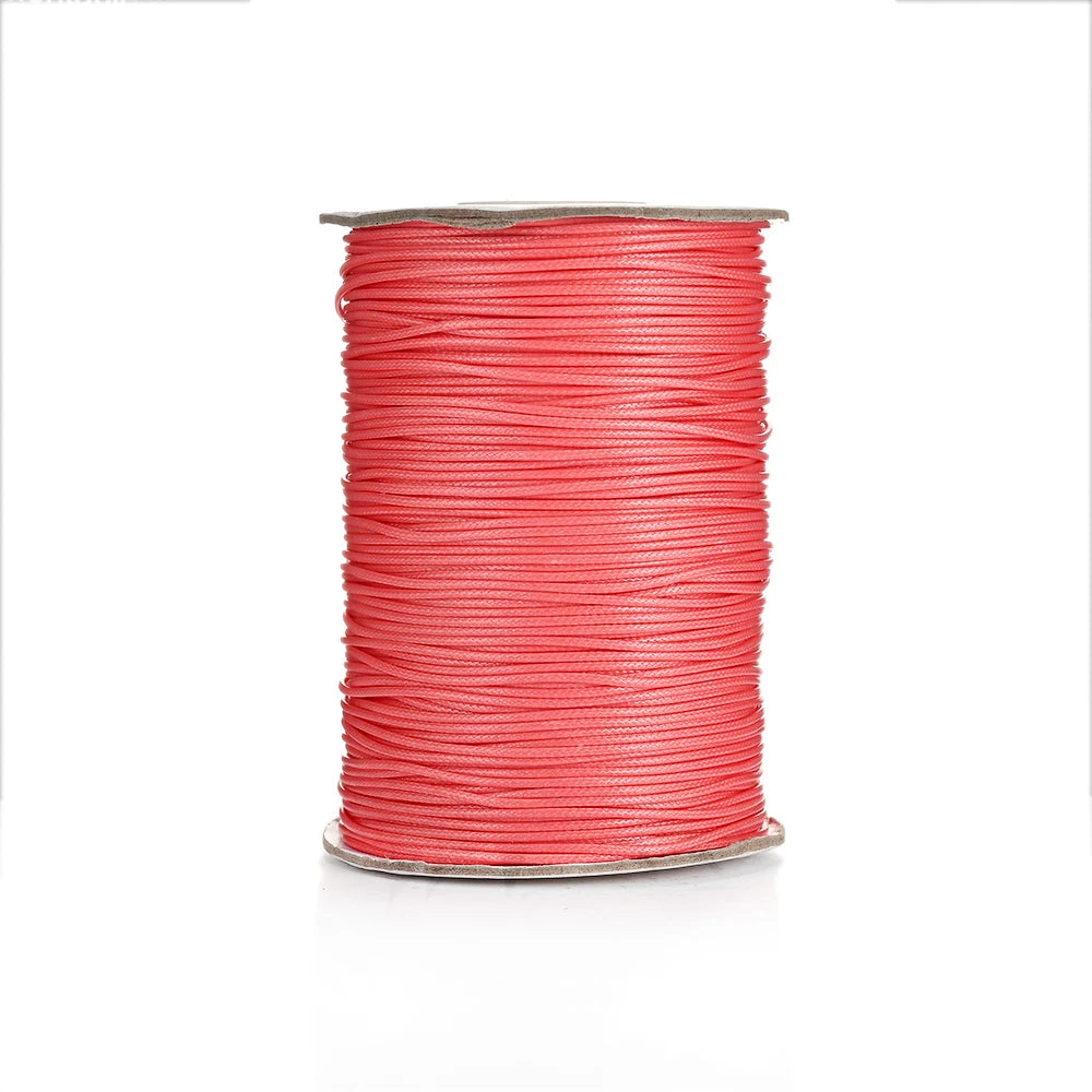 A spool of bright red waxed cotton cord used for jewelry making.