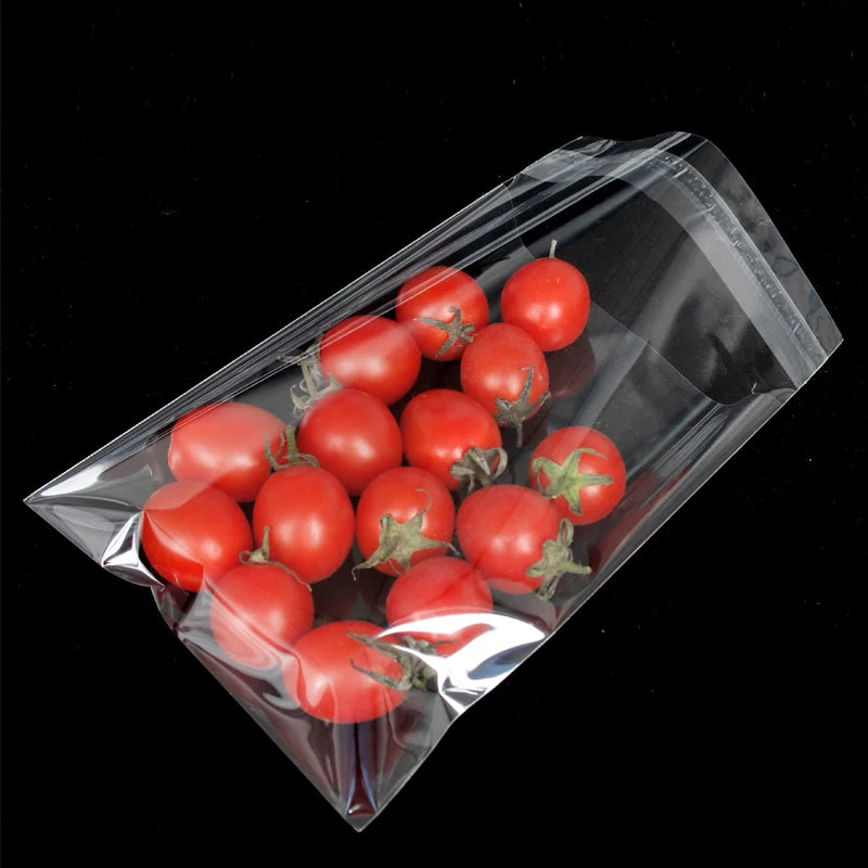 A clear self-adhesive resealable storage bag filled with red cherry tomatoes.