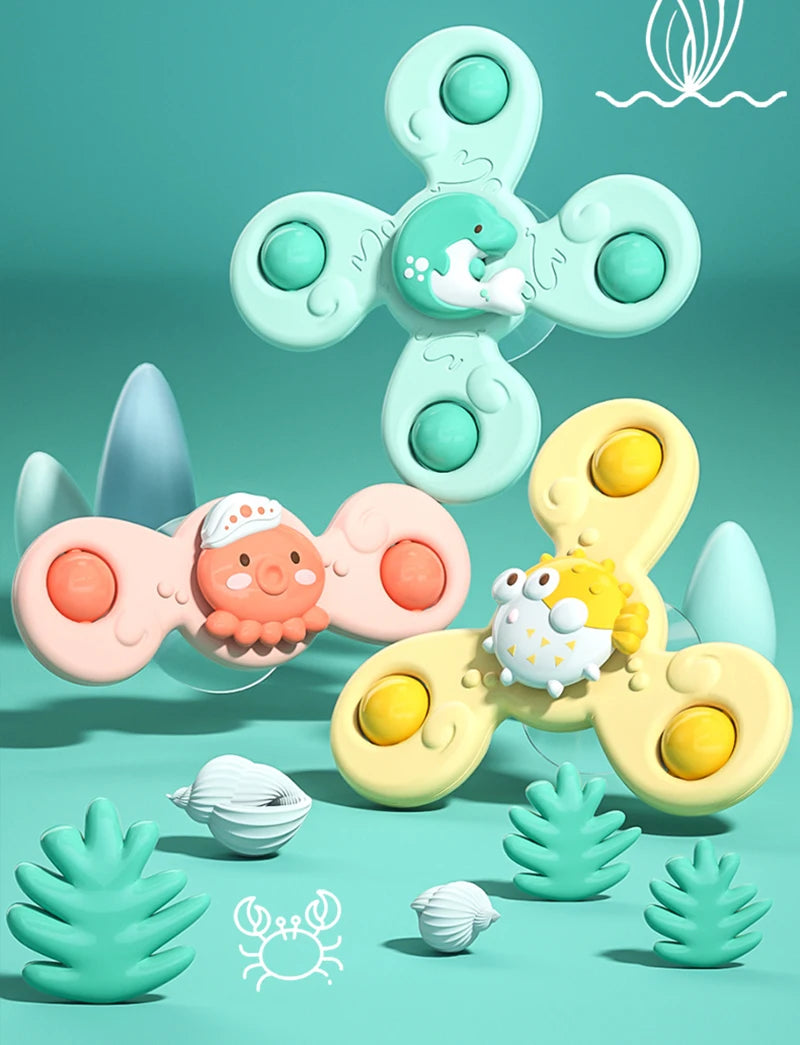 A light green suction cup spinner bath toy featuring a smiling sea creature and various shapes for toddlers.