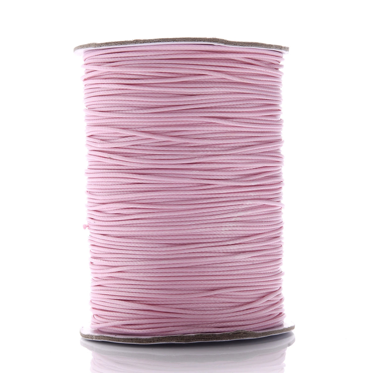 A spool of pink waxed cotton cord used for jewelry making