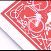 A close-up of a red and white marked stripper deck featuring bicycle motifs and decorative patterns.