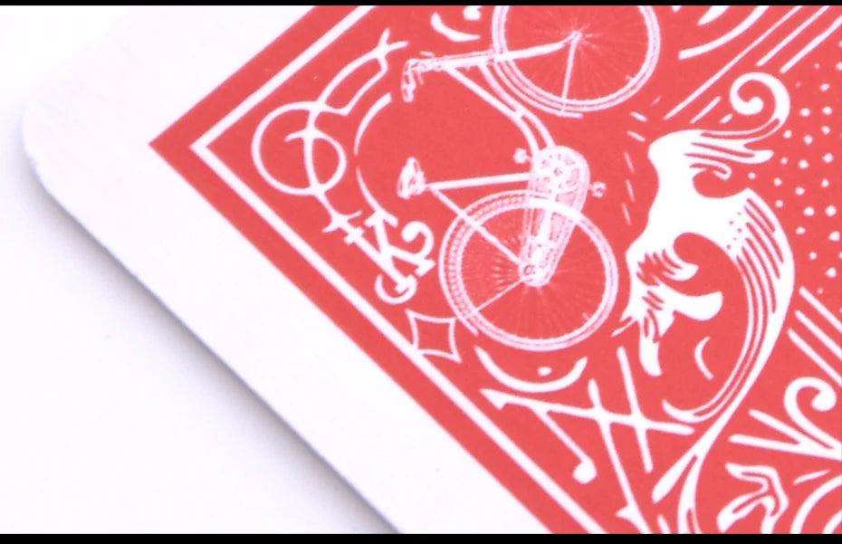 A close-up of a red and white marked stripper deck featuring bicycle motifs and decorative patterns.