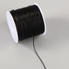 Black elastic crystal beading cord wound on a white spool with a black electrical wire extending from it.