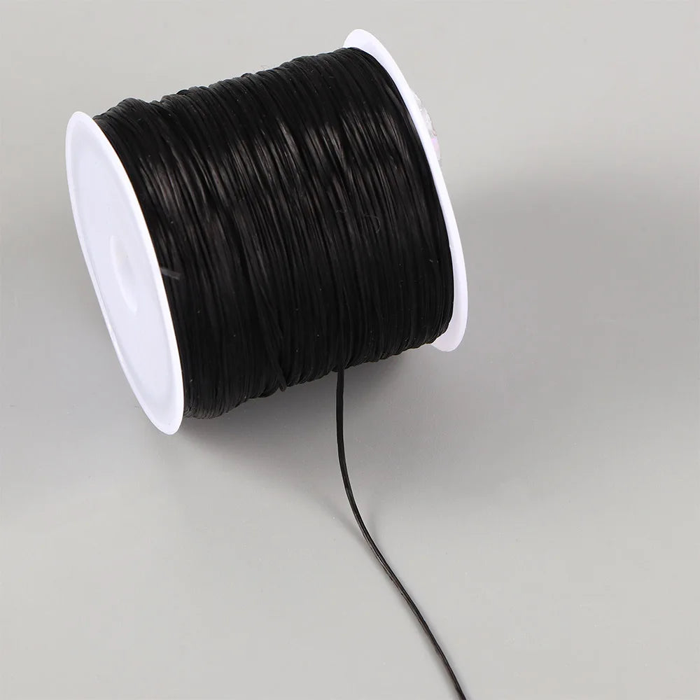 Black elastic crystal beading cord wound on a white spool with a black electrical wire extending from it.