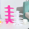 Pink and white stackable display stands for holding sunglasses and reading glasses