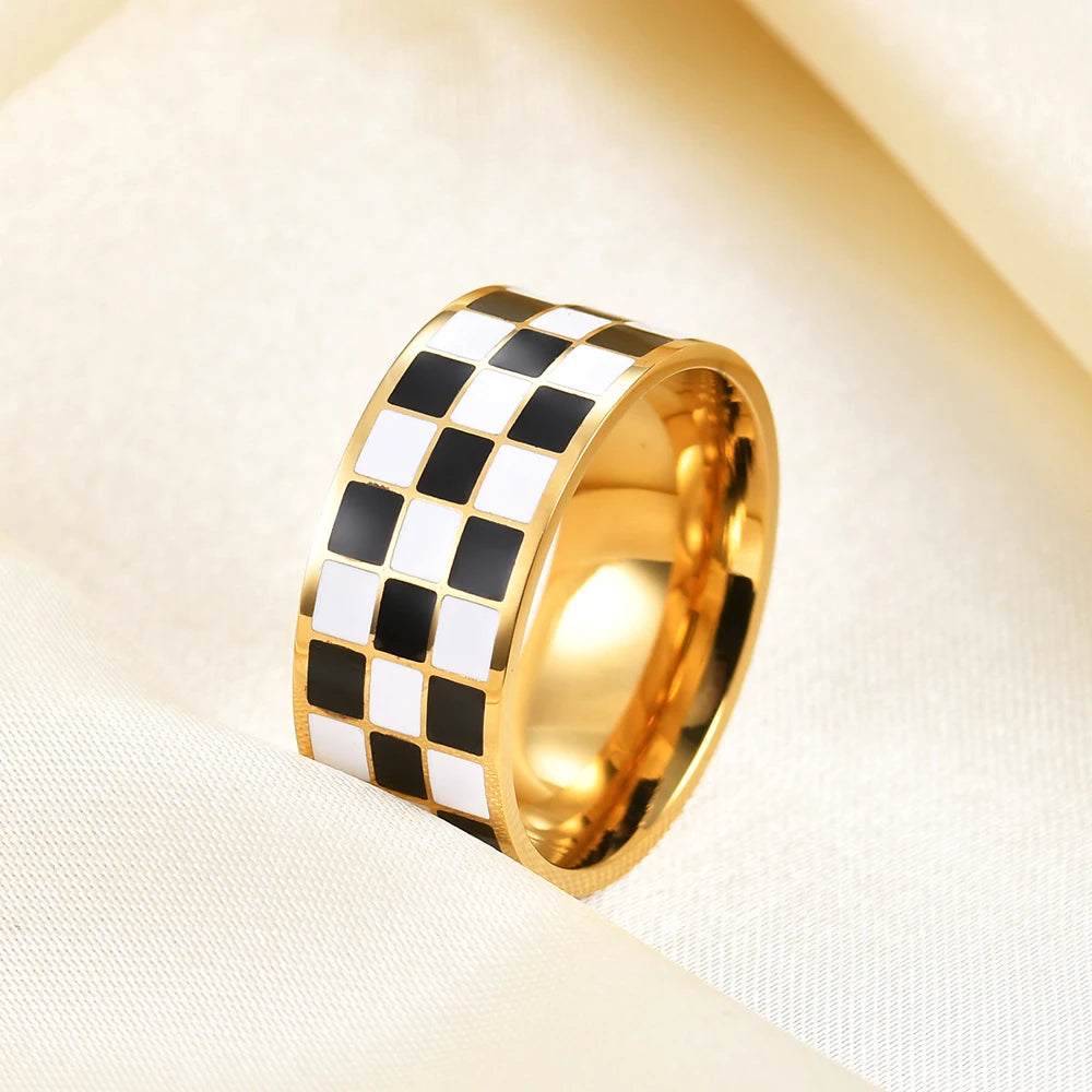 A chunky gold ring featuring a black and white checkerboard pattern.