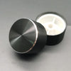 A black aluminum knob with a knurled finish is shown next to its white housing.