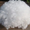 A pile of white soft polyester pearl cotton stuffing for pillows and DIY crafts.