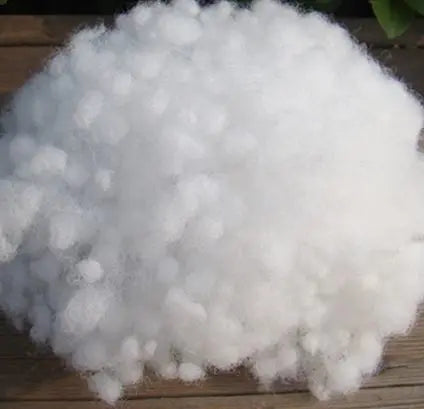 A pile of white soft polyester pearl cotton stuffing for pillows and DIY crafts.