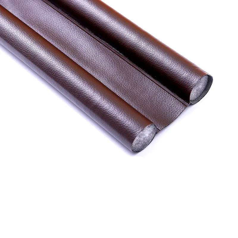 Two rolls of dark brown flexible door bottom sealing strip material.