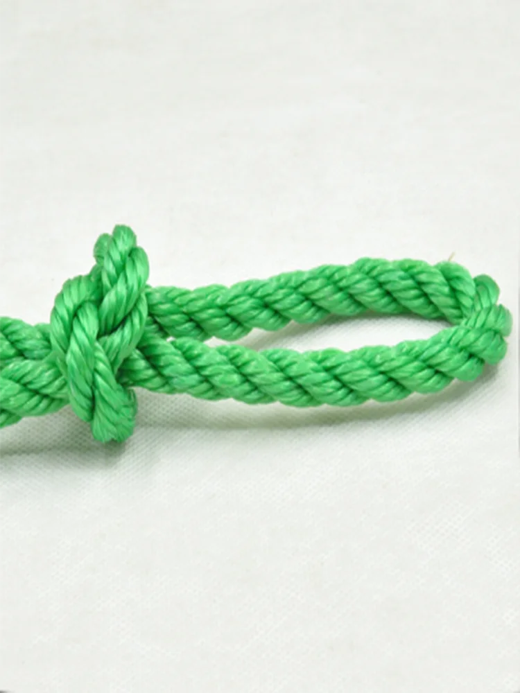 A thick green heavy-duty polyethylene rope tied in a knot, lying on a white surface.