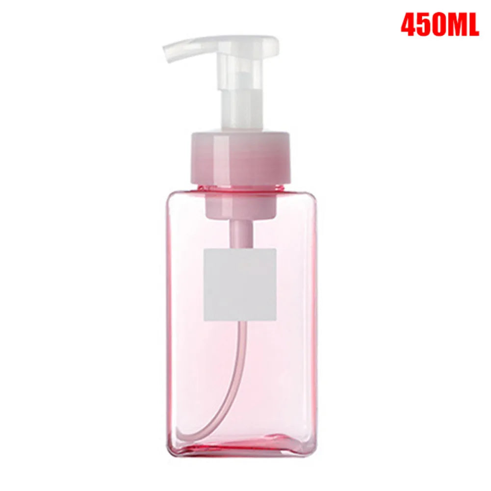 A pink portable manual foam soap dispenser bottle with a white pump top.