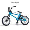 Blue 1/10 scale RC mountain bike with accessories like a shovel, fire extinguisher, and oil drum