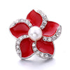 A red flower snap button with a pearl center and silver-toned metal setting for jewelry making
