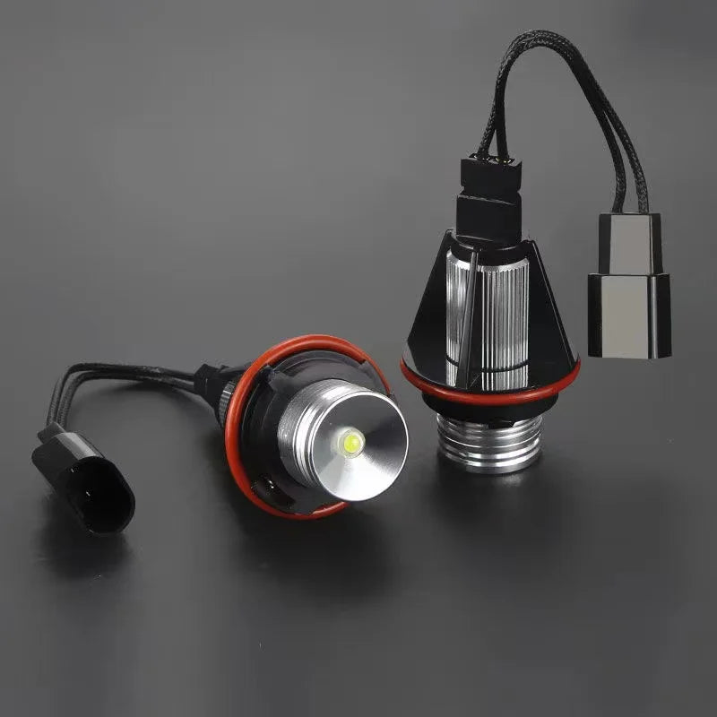 A close-up view of an LED angel eyes marker light bulb with a black connector and silver housing.