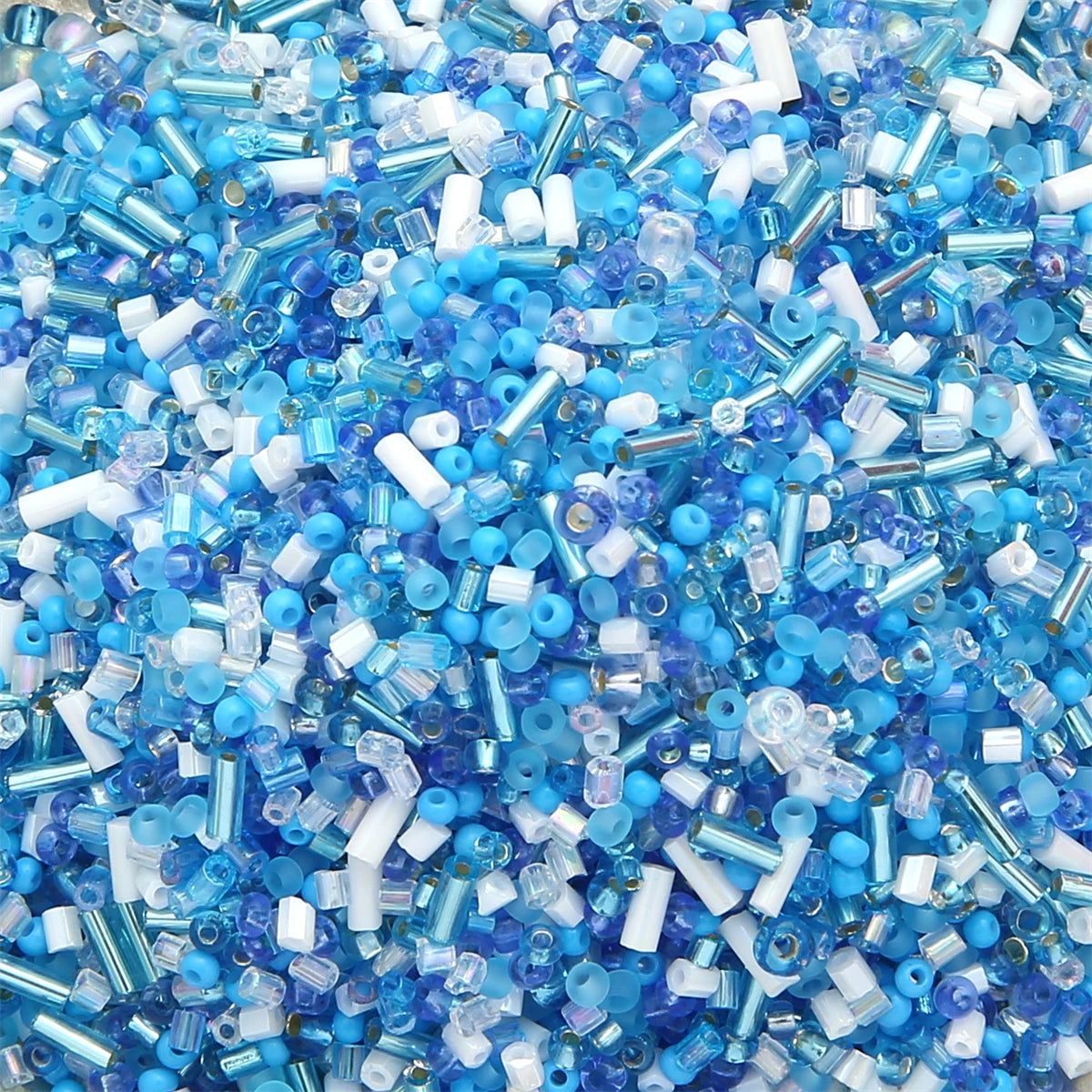 A close-up view of mixed glass seed beads in shades of blue and purple for jewelry making