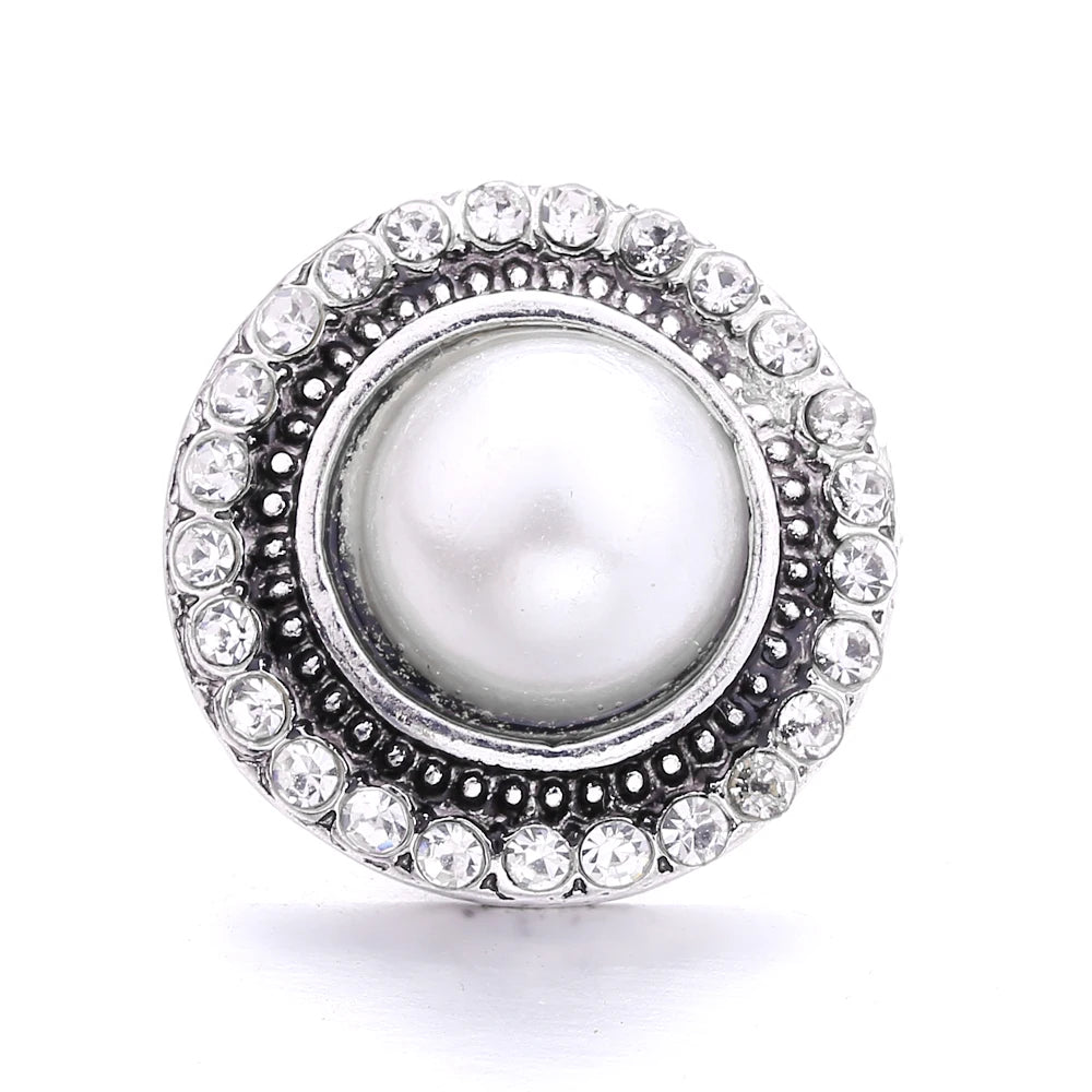 Silver metal snap buttons for jewelry making featuring a central white pearl surrounded by clear stones