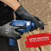 A hand wearing black cut-resistant work gloves is holding a blue handheld tool with a metal tip.