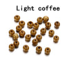 A collection of light brown, natural wooden spacer beads scattered on a white background.