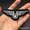 Black embroidered punk skull patches with white wings and star design shown in a hand.