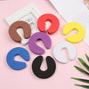 A collection of colorful foam door stoppers with finger pinch protection in various shades including red, purple, yellow, blu