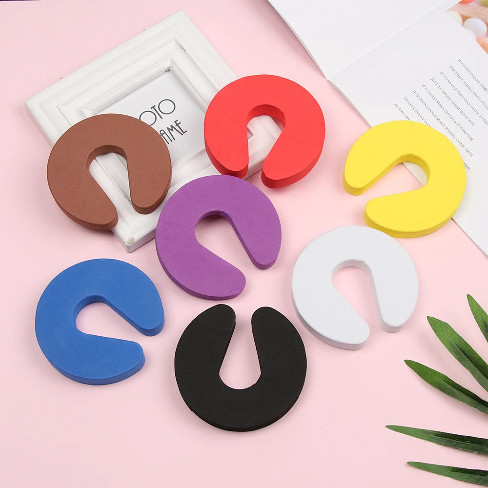 A collection of colorful foam door stoppers with finger pinch protection in various shades including red, purple, yellow, blu