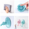 A hand demonstrates a heavy-duty suction cup hook with a strong vacuum seal, showing its use and attachment to a surface.