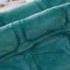 Close-up of a teal velvet bedspread featuring a quilted, non-slip texture.