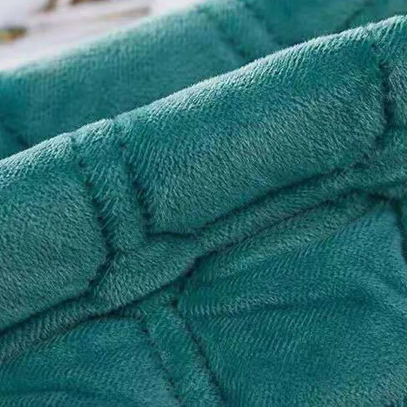 Close-up of a teal velvet bedspread featuring a quilted, non-slip texture.